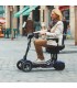 Persona conduciendo ágilmente el scooter CITY por una calle de la ciudad.